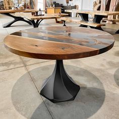 an oval table with two benches in the back and one bench at the front on concrete flooring