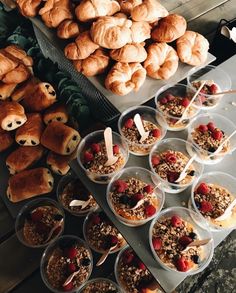 there are many pastries and desserts on the table with spoons next to them