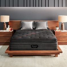 a large bed sitting on top of a wooden platform in a bedroom next to two nightstands