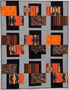 an orange and black patchwork quilt with squares