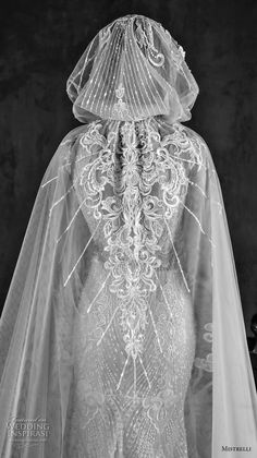 the back of a wedding dress with veil on it's head and neck, in black and white