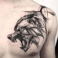 a man's chest with a wolf tattoo on it