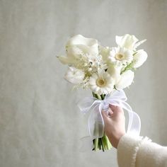 a person holding a bouquet of white flowers