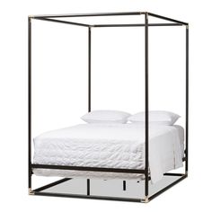 an iron bed frame with white sheets and pillows on it, against a white background