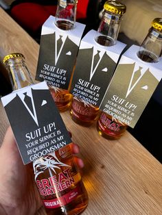 someone holding up three bottles of liquor with labels on them that say sullip, your service is gourmet