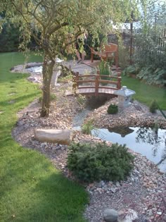 a wooden bridge over a small pond in a garden