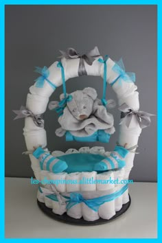 a diaper cake with an elephant in the center and blue ribbon around it's edges