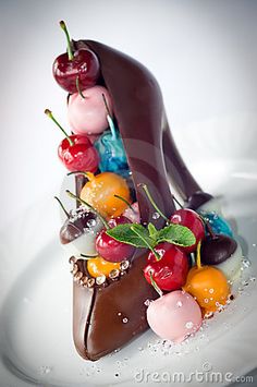 a piece of chocolate cake with cherries on top and other fruit in the shape of a woman's legs