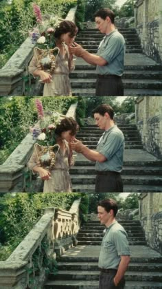 a man and woman standing next to each other in front of some stairs with flowers on them