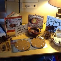 there are many books on the table with spider webs around them and other items