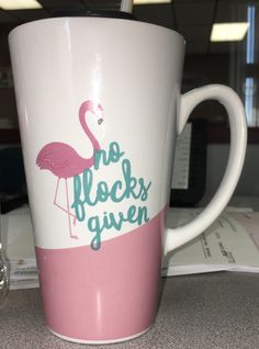 a pink and white coffee cup with a flamingo on it that says no flocks given