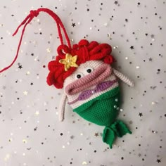 a crocheted christmas ornament with a fish on it's tail