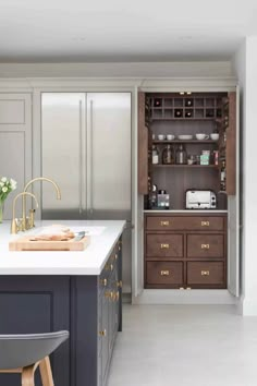 a kitchen with white counter tops and wooden cabinets in the center, along with an island