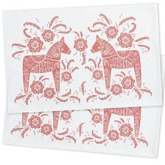 two red and white paper napkins with horses in floral designs on the front side