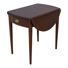 a small wooden table with an oval shaped drawer on one side and two drawers on the other