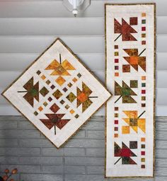 two quilts hanging on the wall next to each other