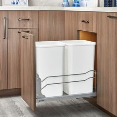 an open dishwasher in a kitchen with wooden cabinets