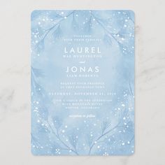 a blue wedding card with snowflakes and pine branches in the middle, on a white background