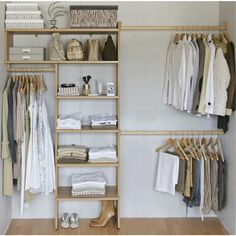 an organized closet with clothes, shoes and other items on shelves in front of a white wall