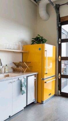 a yellow refrigerator sitting in the middle of a kitchen