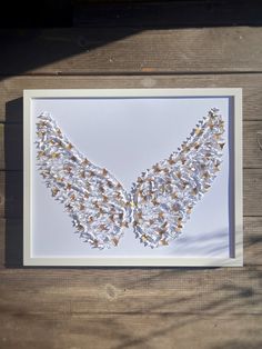 an image of a white and gold necklace made out of flowers on a wooden table