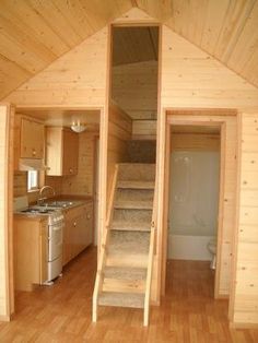 an instagramted photo of a tiny cabin with stairs leading up to the loft