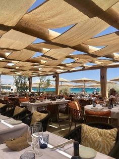 an outdoor dining area with tables, chairs and umbrellas