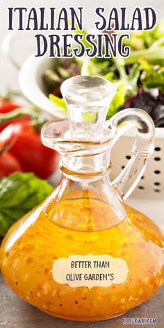 a glass bottle filled with salad dressing sitting on top of a table next to vegetables