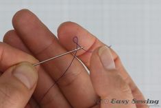 two hands are holding a needle and thread