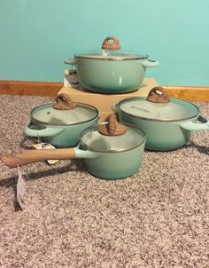 a group of pots and pans sitting on top of a carpeted floor next to a wall