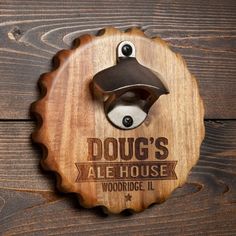 a bottle opener mounted to the side of a wooden plaque that says doug's ale house