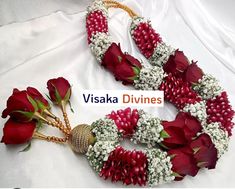 red roses and white baby's breath flowers are arranged in a wreath on a bed