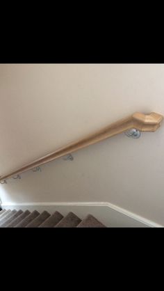 a set of stairs with wooden handrails on the wall and carpeted floor