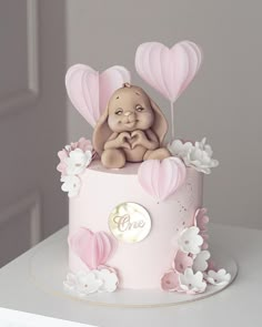 a pink cake decorated with hearts and an elephant on top