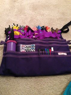 a purple bag filled with lots of items on the floor