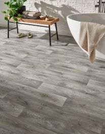 a white bath tub sitting next to a wooden floor