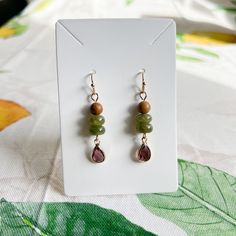 Gold Dangle Earrings Feature Wood Beads, Wine Ruby Garnet Red Crystal Glass Teardrops, Forest Moss Colored Deep Green Jade Beads And French Ball Ear Hooks. Also Available As A Set Approximately 2 Inch Drop Earrings Come With Silicone Stoppers Ships Within 2 Business Days Customization Available Made To Order Made With Love And Care Wine Ruby Garnet Red Crystal Forest Moss Green Jade Wood Bead Casual Earrings / Boho, Western, Dainty, Every Day, Daily Wear, Nature Earrings, Natural Stone, Beads, A Crystal Forest, Forest Moss, Bead Dangle Earrings, Earthy Jewelry, Casual Earrings, Garnet Red, Nature Earrings, Gold Dangle Earrings, Earring Ideas