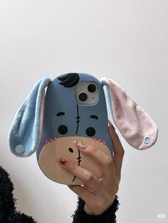 a person holding up a cell phone case with a dog on it's face