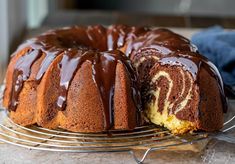 a bundt cake with chocolate icing on a cooling rack