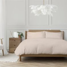 a bedroom with white walls and wooden furniture