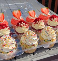 cupcakes with white frosting and strawberries on top