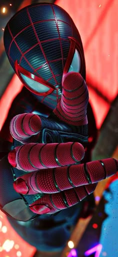 a spider man statue sitting on top of a table next to a red and blue light