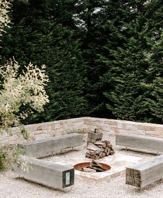 an outdoor fire pit surrounded by trees and gravel