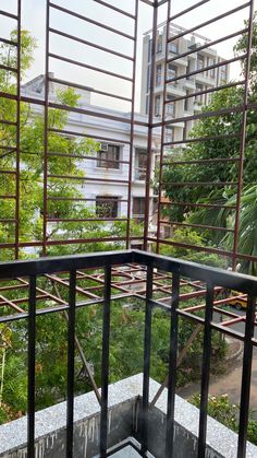 an open balcony with metal railings and green trees in the backgroung