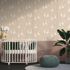 a white crib in front of a wall with ducks on it and a potted plant next to the crib