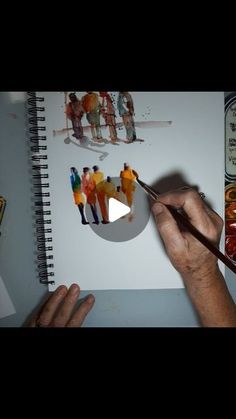 someone is painting pictures on paper with watercolors