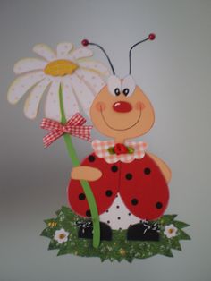 a lady bug holding a flower on top of grass