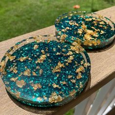 two blue and gold plates sitting on top of a wooden table next to each other