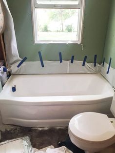 the bathroom is being remodeled with blue tape on the tub and toilet in the corner