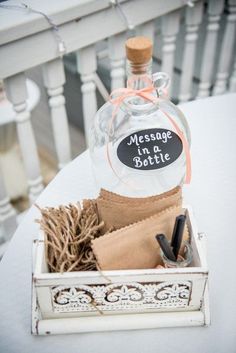 a bottle of wine sitting on top of a white table next to some brown paper